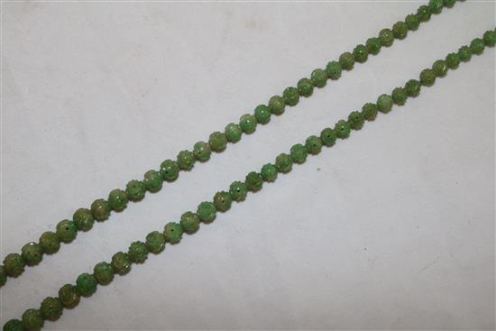 A Chinese carved jadeite bead necklace, early 20th century, total length 72.5cm, largest bead 9mm